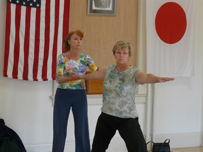 Anita positioning a student in warrior two pose